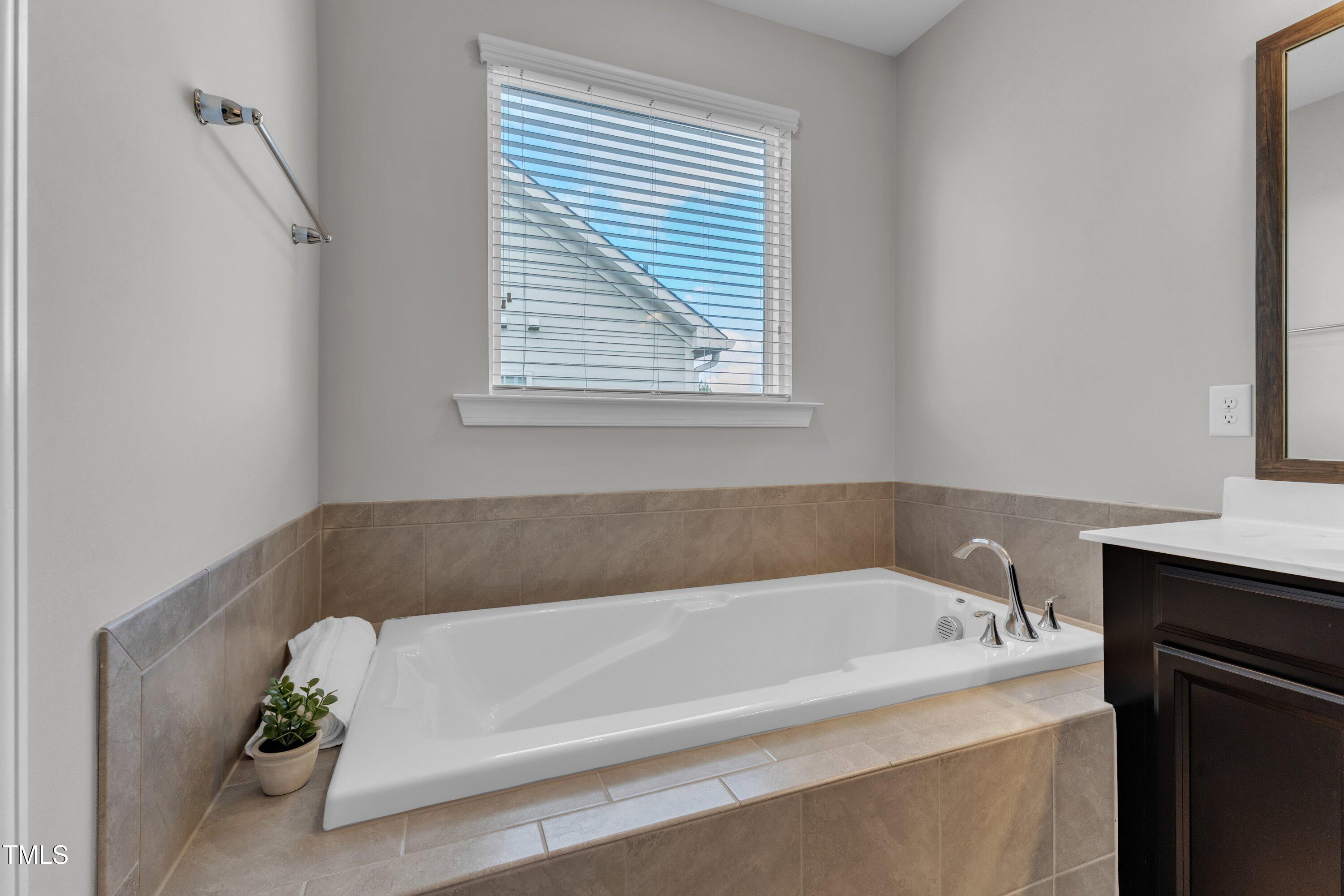 4252 Rockdell Hall Street Raleigh, NC 27616 - Photo 52 of 64 a bathroom with a bathtub and a window