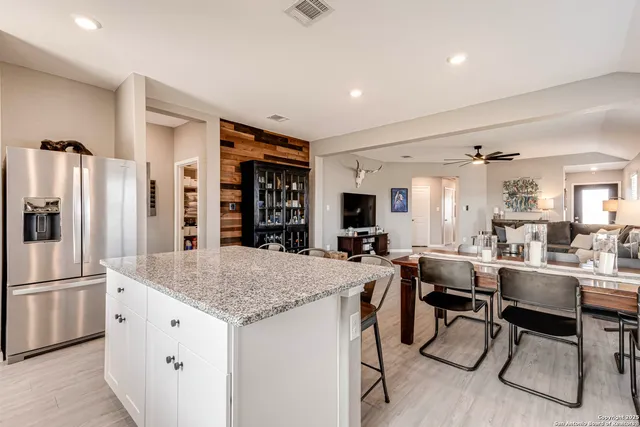 a kitchen with stainless steel appliances granite countertop table chairs and refrigerator