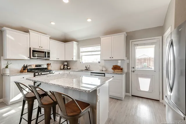 a kitchen with a dining table chairs and refrigerator