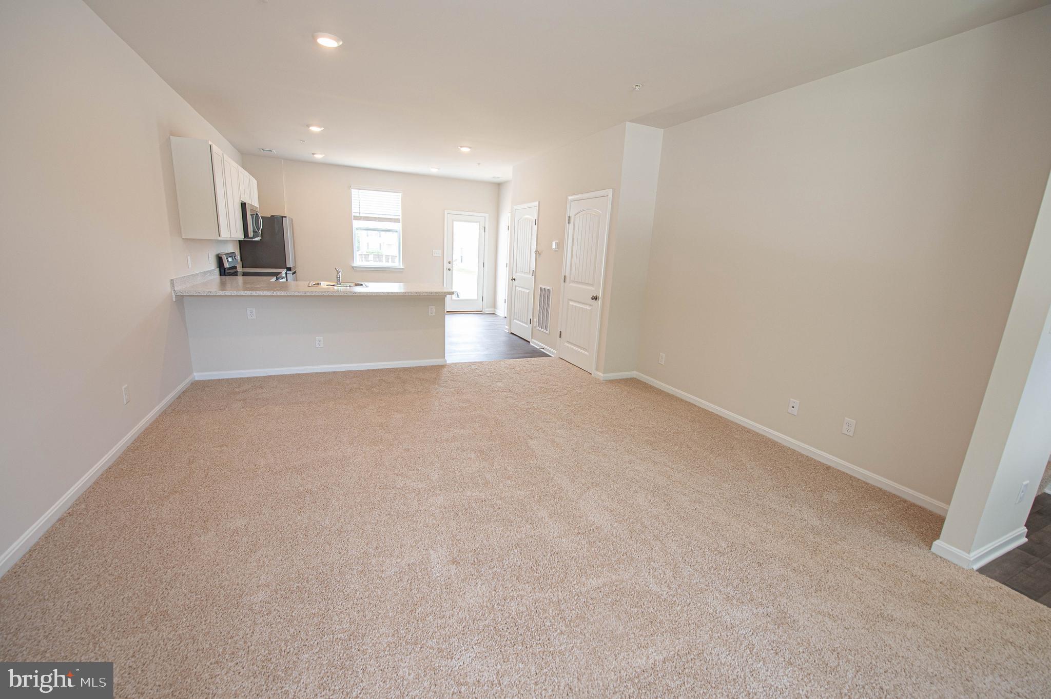 130 Willowtree Lane Fruitland, MD 21826 - Photo 17 of 74 a view of kitchen and empty room with wooden floor