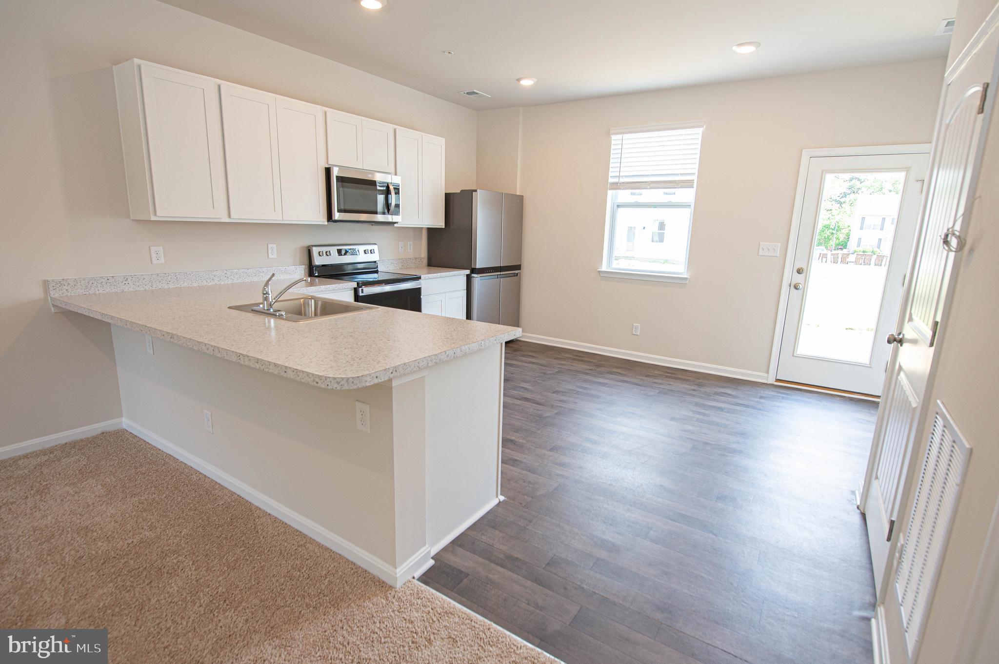 130 Willowtree Lane Fruitland, MD 21826 - Photo 22 of 74 a kitchen with stainless steel appliances granite countertop a sink stove refrigerator and microwave