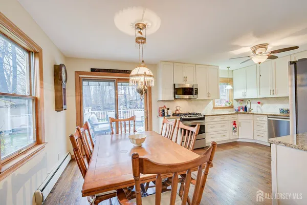 a open kitchen with stainless steel appliances granite countertop a stove a refrigerator a kitchen island a table and chairs