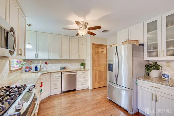 a kitchen with stainless steel appliances a refrigerator sink and microwave