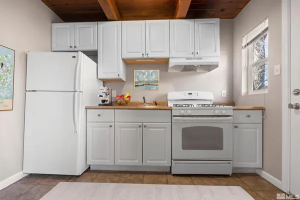 a kitchen with white cabinets and white appliances