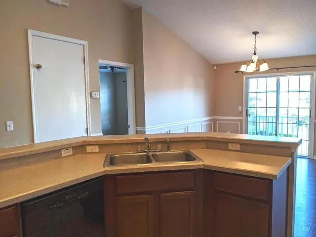 a sink with a window and wooden cabinets
