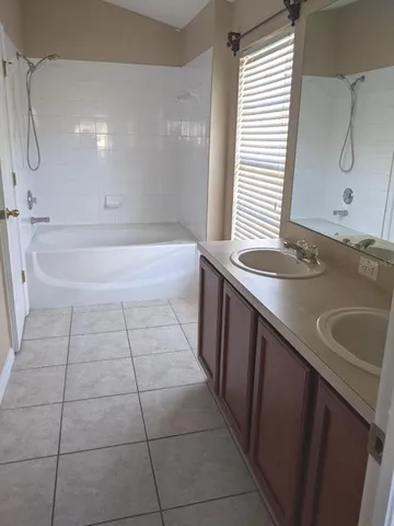 a bathroom with a sink a toilet a mirror and bathtub