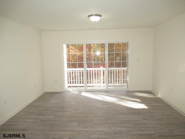 35 Apache Court, Unit 35 Galloway Township, NJ 08205 - Photo 4 of 10 an empty room with wooden floor and windows