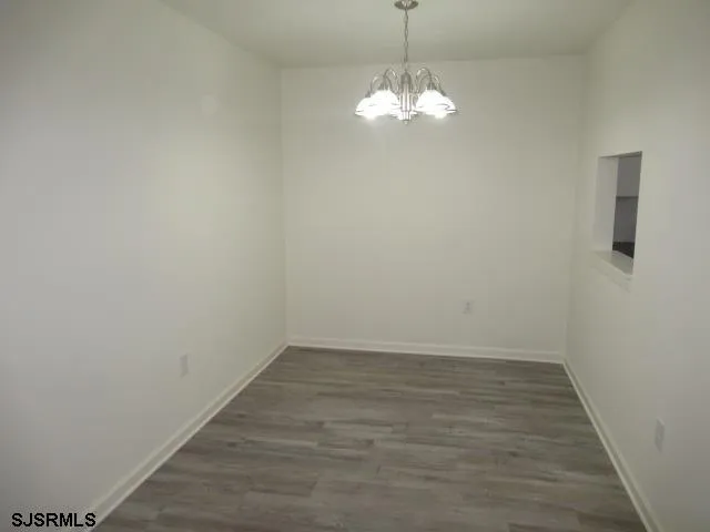 a view of a room with wooden floor and chandelier