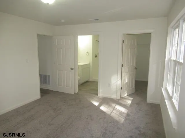 an empty room with windows and closet