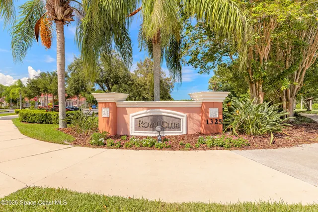 a view of a house with a yard and potted plants