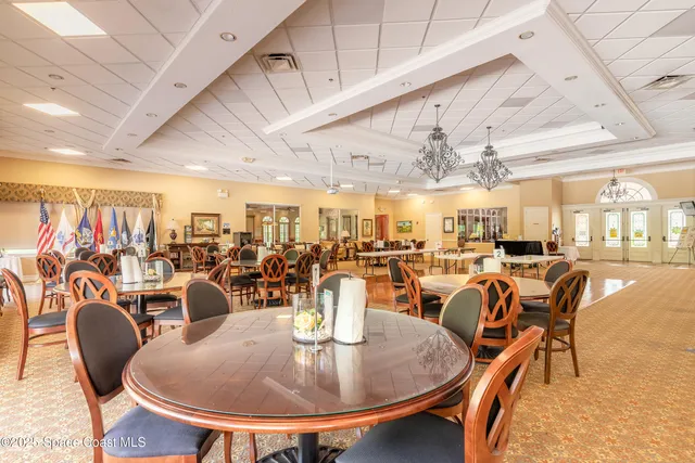 a dining room with lots of tables a chandelier and pool table