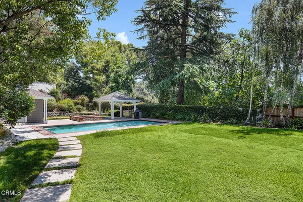 a view of a swimming pool with lawn chairs under an umbrella