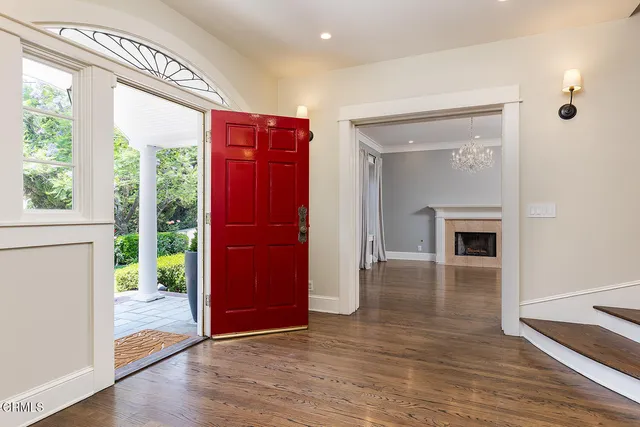 an empty room with wooden floor fireplace and windows