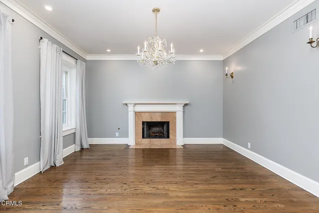 a view of a livingroom with a fireplace wooden floor and chandelier