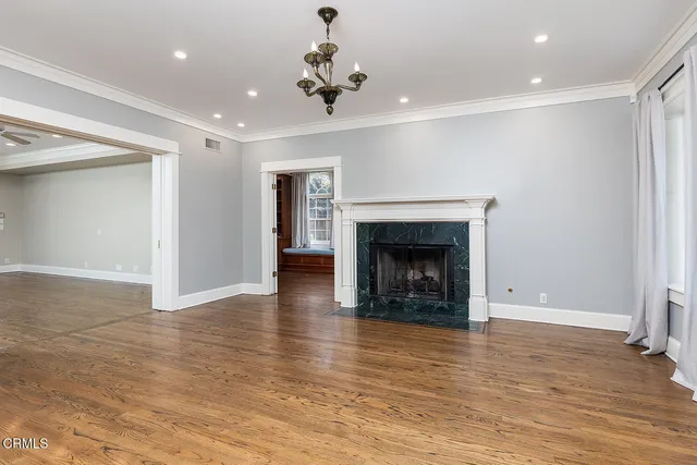 a view of an empty room with a fireplace and a window
