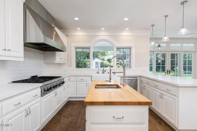 a kitchen with kitchen island a stove a sink and a counter top space