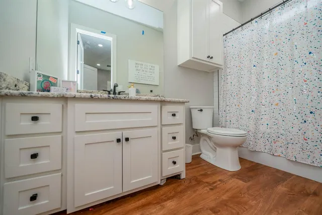 a bedroom with a bed and a wooden floor