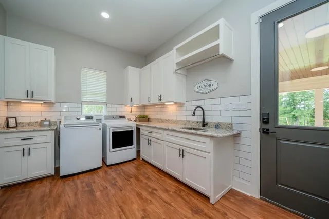 a view of a kitchen with fridge and wooden floor