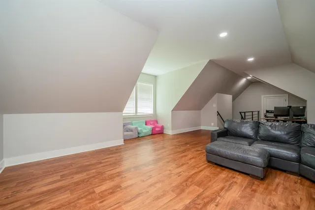 a view of an empty room with wooden floor and windows