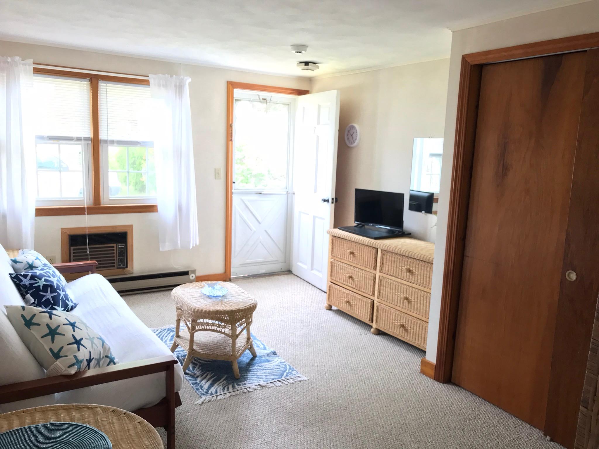 49 Lower County Road, Unit U 7 Dennis Port, MA 02639 - Photo 4 of 23 a living room with furniture a flat screen tv and a window