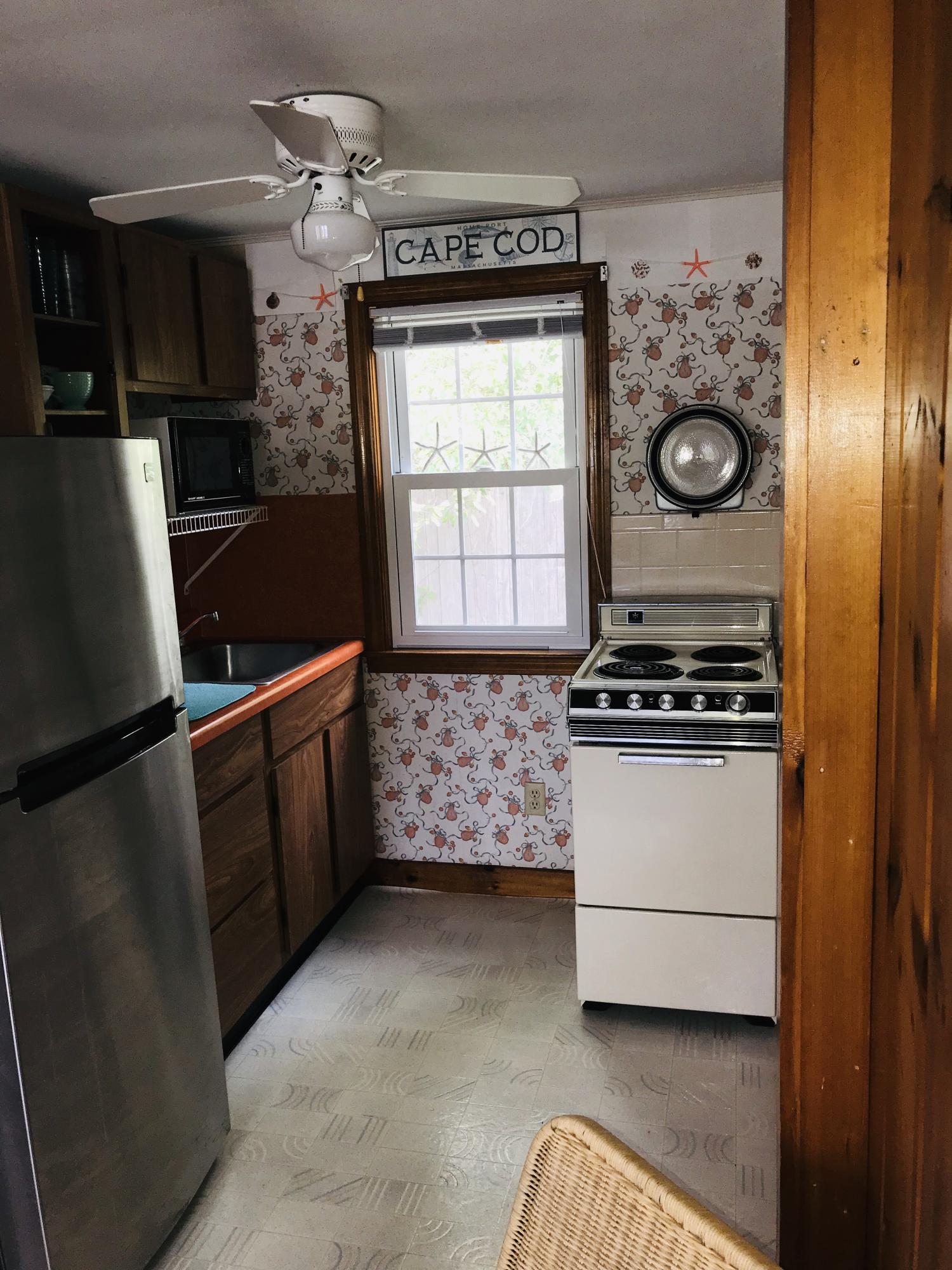 49 Lower County Road, Unit U 7 Dennis Port, MA 02639 - Photo 9 of 23 a kitchen with a refrigerator and a stove