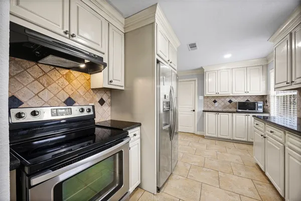 a kitchen with granite countertop a stove and a refrigerator