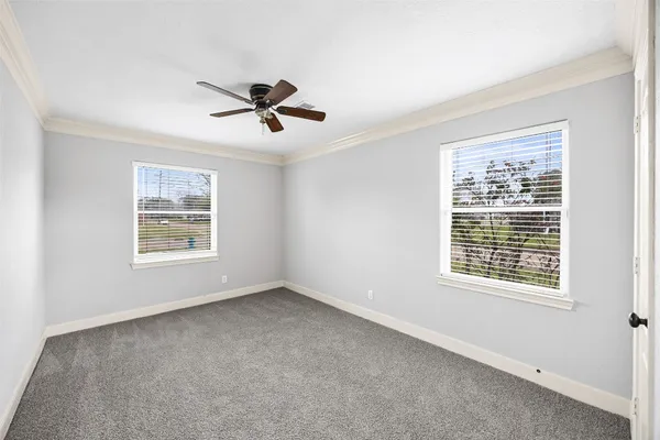 an empty room with a window and a ceiling fan