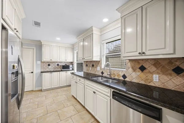 a kitchen with a sink a refrigerator and cabinets