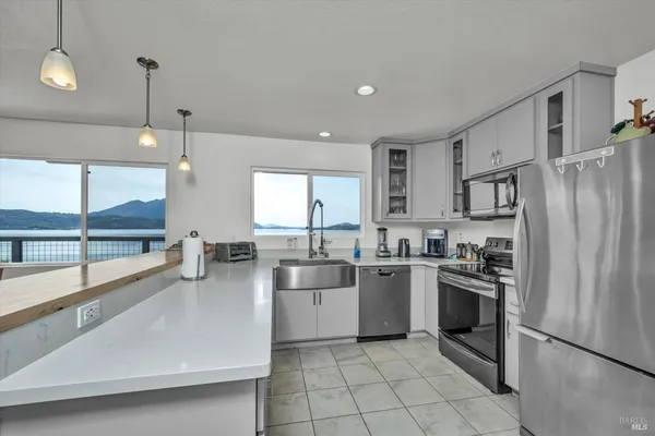 a kitchen with stainless steel appliances granite countertop a sink a stove and a refrigerator