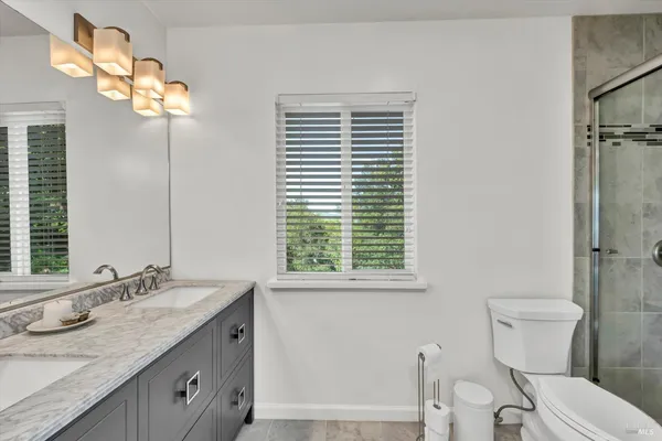 a bathroom with a granite countertop sink a toilet and a mirror