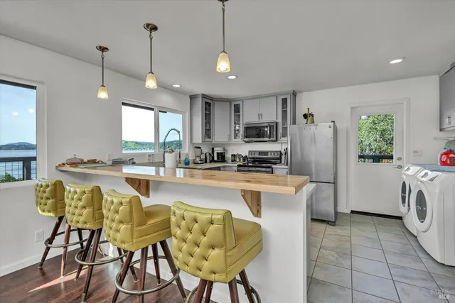 a kitchen with refrigerator and chairs