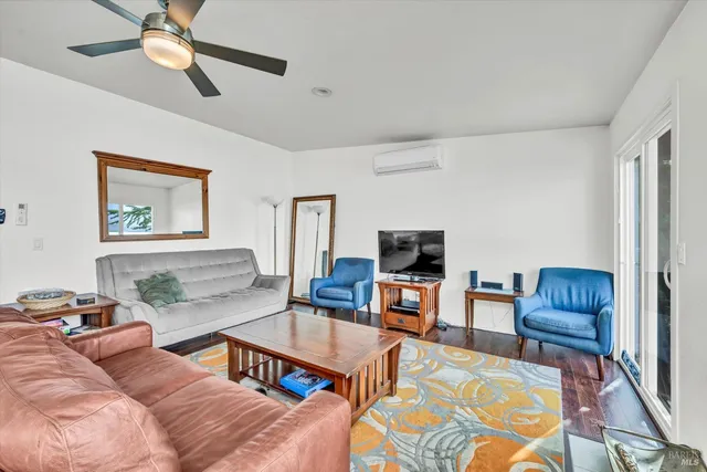 a living room with furniture a flat screen tv and a window