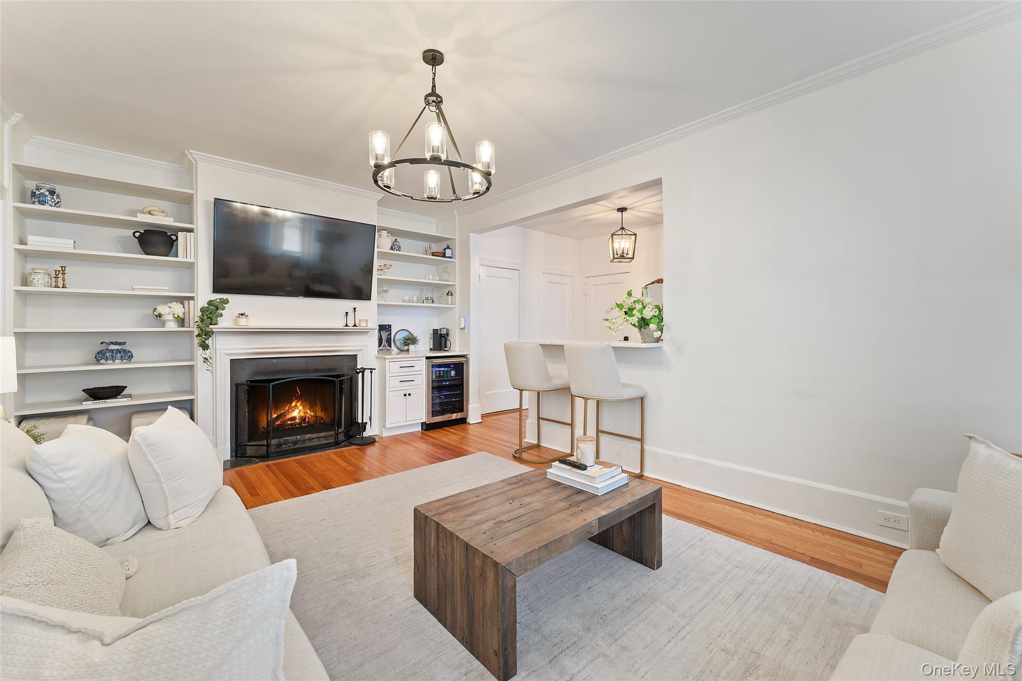 840 Bronx River Road, Unit 5B Bronxville, NY 10708 - Photo 3 of 5 Living Room features a wood burning fireplace with built-ins and beverage refrigerator.
