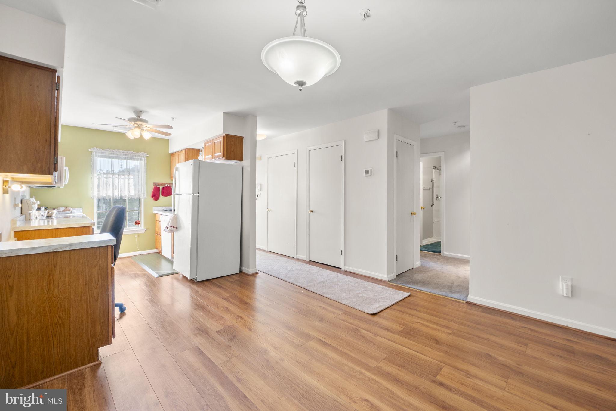 9268 Cherry Lane, Unit 62 Laurel, MD 20708 - Photo 6 of 23 a view of a kitchen with wooden floor and a refrigerator