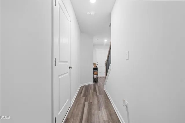 a view of a hallway with wooden floor and staircase