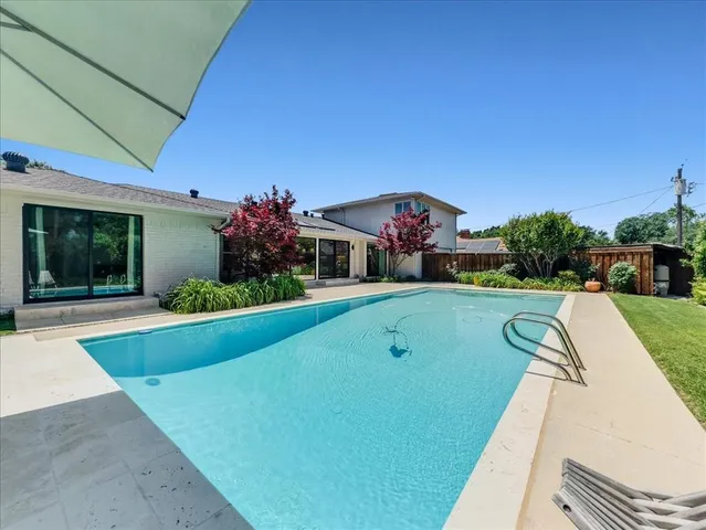 a view of house with swimming pool and yard