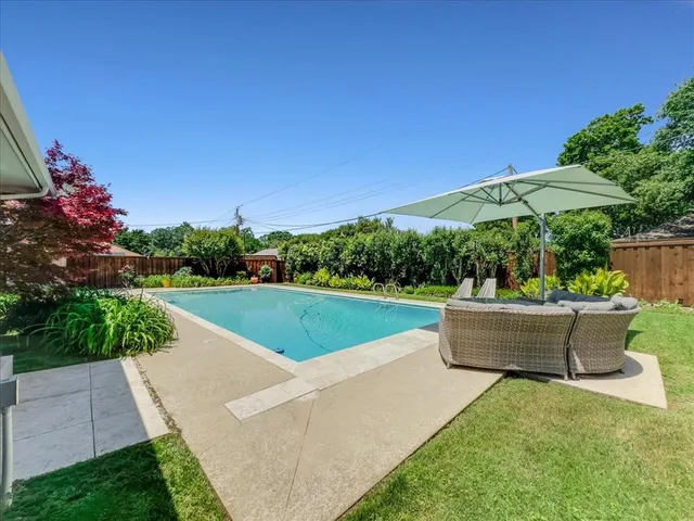 a view of building with garden space and car parked