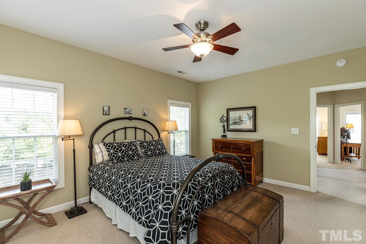 3512 Edgemont Drive Raleigh, NC 27612 - Photo 19 of 30 a bedroom with a large bed chandelier and a window