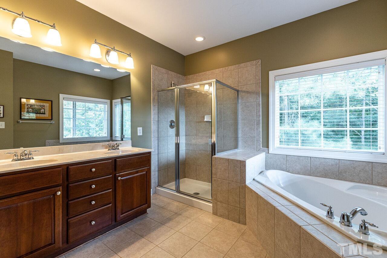 3512 Edgemont Drive Raleigh, NC 27612 - Photo 20 of 30 a spacious bathroom with a tub sink shower and mirror