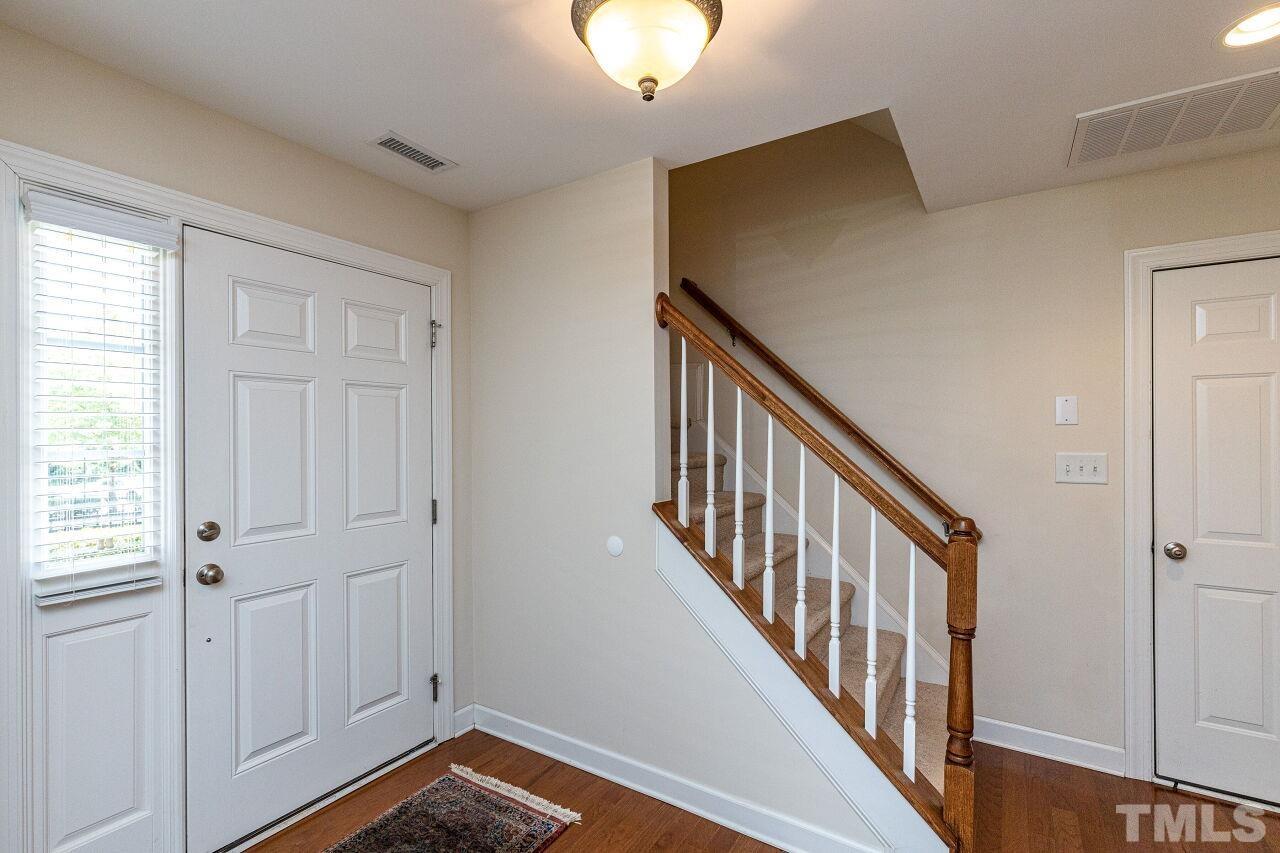 3512 Edgemont Drive Raleigh, NC 27612 - Photo 4 of 30 a view of a hallway with wooden floor and staircase