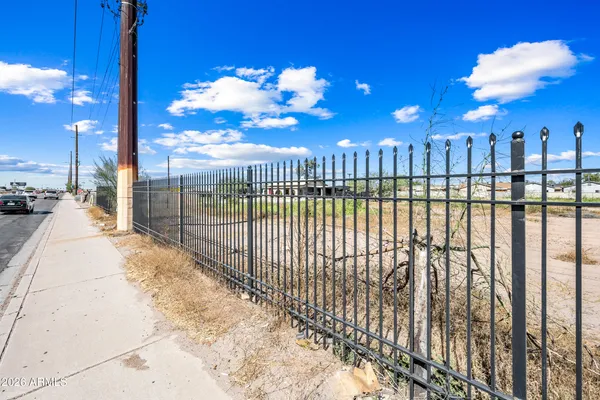 a view of a pathway with a wrought fence