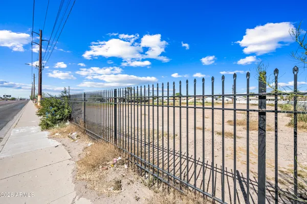 a view of a pathway with a wrought fence
