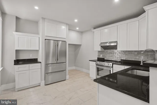 a kitchen with granite countertop white cabinets and stainless steel appliances