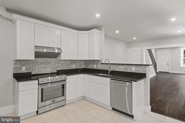 a kitchen with granite countertop a sink and stainless steel appliances