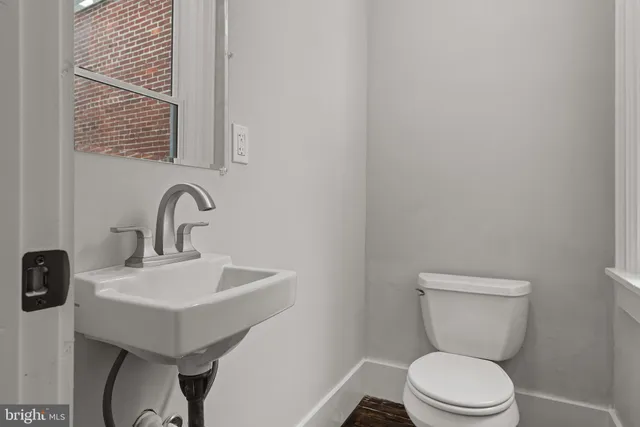 a bathroom with a toilet a sink and a mirror