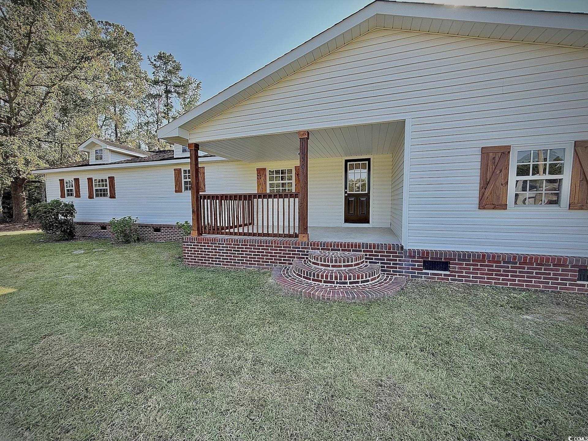 View of front of home featuring a porch and a front lawn