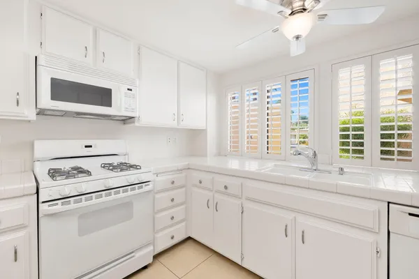 a large white kitchen with white cabinets and white appliances