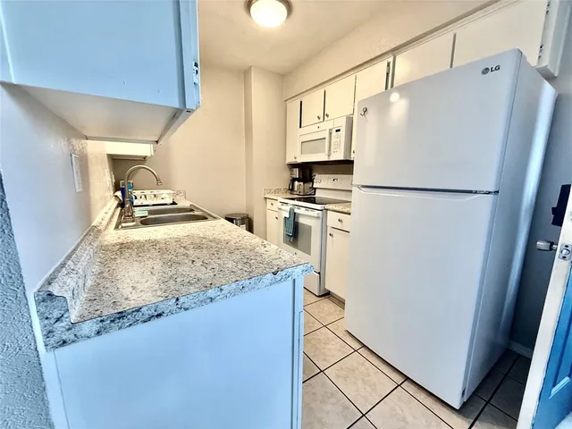 a white refrigerator freezer sitting in a kitchen