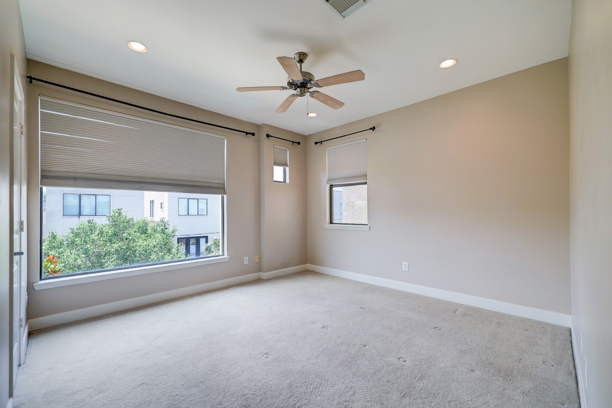 5202 Rose Street, Unit B Houston, TX 77007 - Photo 29 of 40 This bright room features neutral walls, a ceiling fan, and large windows with blinds, offering ample natural light and a view of the surrounding area. Perfect for use as a bedroom or office.