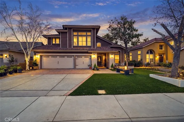 a front view of a house with garden and trees